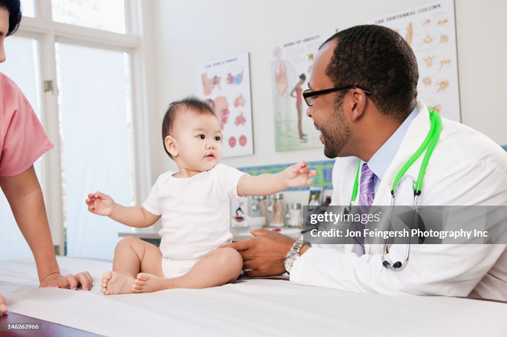 Doctor and nurse examining baby in doctor's office