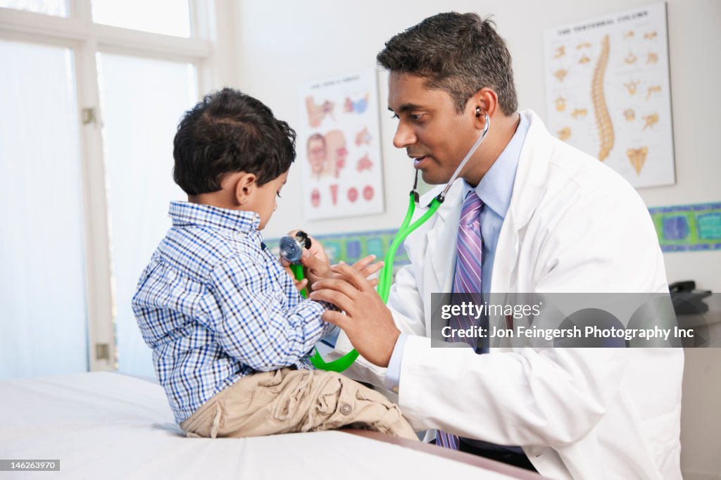 Indian doctor examining boy in doctor's office