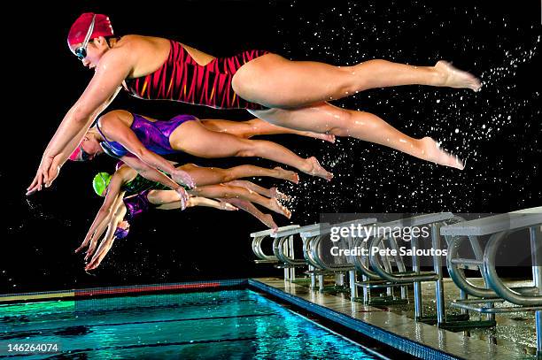 swimmers diving off starting blocks - girl diving stockfoto's en -beelden