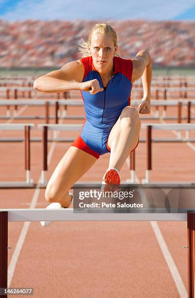 europäischer abstammung läufer springen über hürden auf track - hurdling track event stock-fotos und bilder