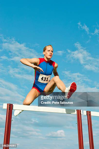 europäischer abstammung läufer springen über hürden auf track - hurdling track event stock-fotos und bilder