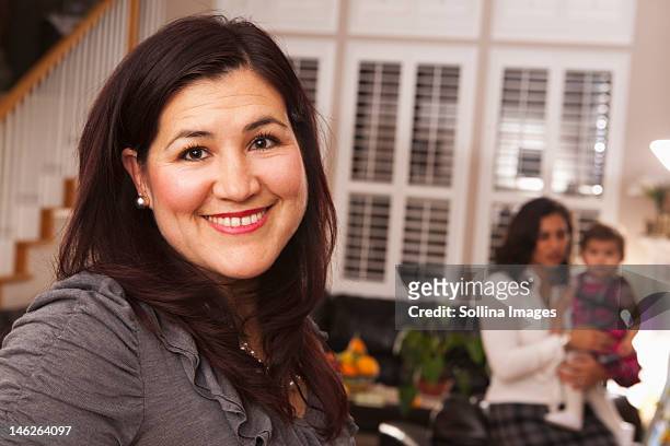 hispanic woman in living room with family - aunyy stock pictures, royalty-free photos & images
