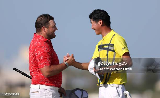 Zander Lombard of South Africa shakes hands with Rikuya Hoshino on the 18th green during the third round of the Ras Al Khaimah Championship at Al...