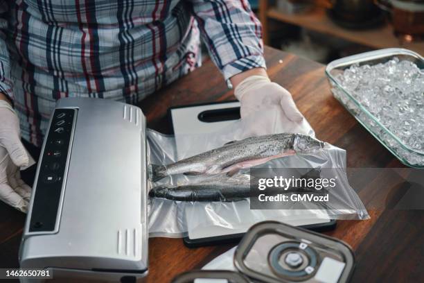 food safety - preserving fresh trout fish in a plastic bag with a vacuume sealer - vacuum packed bildbanksfoton och bilder