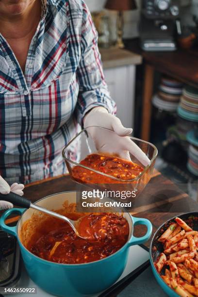 seguridad alimentaria - conservación de las sobras de chili con carne en un recipiente de vidrio hermético - chili woman fotografías e imágenes de stock