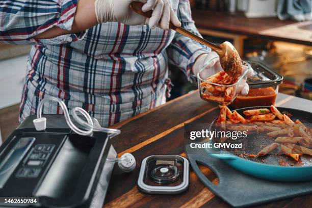 food safety - preserving leftover tomato penne pasta in a airtight glass container - vacuum stockfoto's en -beelden