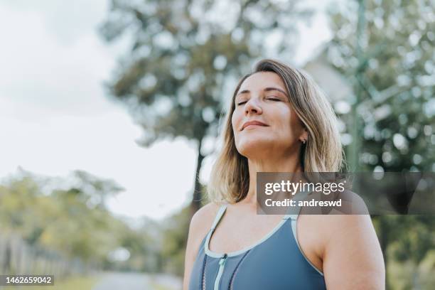 portrait of a woman breathing fresh air - exercício respiratório imagens e fotografias de stock