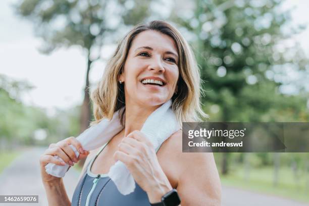 portrait of a sporty woman smiling - vrouw 50 jaar stockfoto's en -beelden
