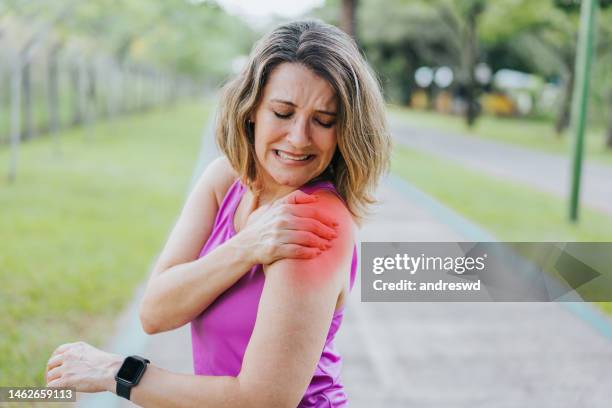 portrait of mature woman with shoulder pain - muscle cramps stock pictures, royalty-free photos & images