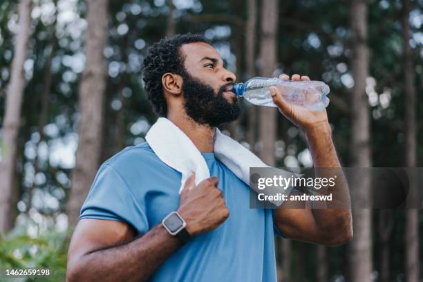 portrait of a sporty man drinking water - água potável imagens e fotografias de stock