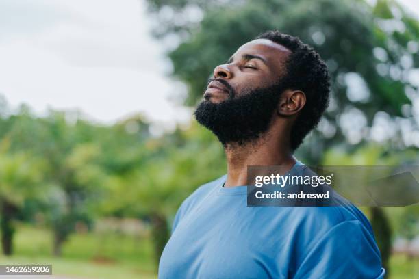 retrato de un hombre respirando aire fresco en la naturaleza - gente serena fotografías e imágenes de stock