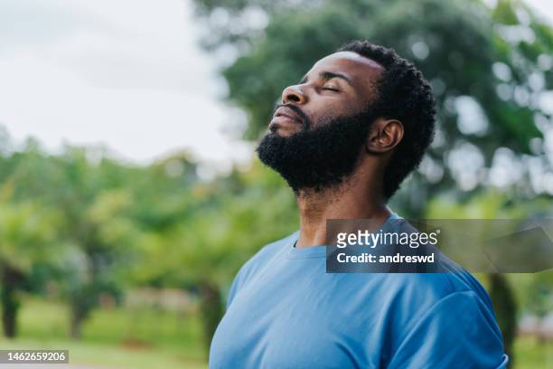 portrait of a man breathing fresh air in nature - fitness man stockfoto's en -beelden