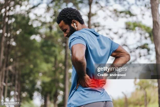 portrait of a mature man with back pain - back pain stock pictures, royalty-free photos & images