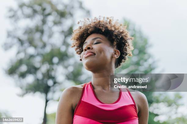 portrait of a serene young woman breathing fresh air - fresh air breathing stockfoto's en -beelden