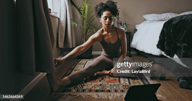 donna nera che allunga le gambe per l'esercizio del laptop a casa, in camera da letto o in casa. la persona sportiva riscalda il corpo sul pavimento per un tutorial di allenamento, un blog di fitness online o imparare lo yoga su computer, internet o tecnol - home workout foto e immagini stock