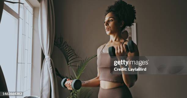 dumbbell exercise, black woman and workout in home, bedroom and apartment for strong body, muscle and wellness. young female person, sports fitness and weights in house for power, training and focus - dumbbell 個照片及圖片檔