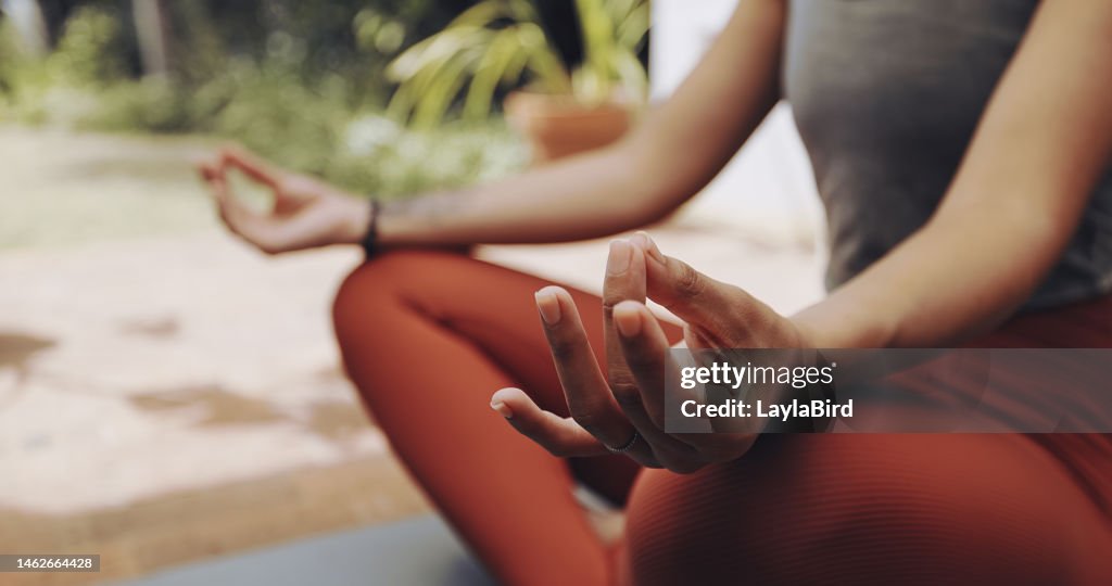 Woman, mudra hands and meditation for wellness, freedom and calm chakra energy in garden, park and zen. Closeup girl, yoga exercise and meditate in lotus outdoors for mental health, hope and mindset