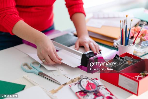 close up of female designer cutting paper for scrap booking greeting postcards - kunstnijverheid stockfoto's en -beelden