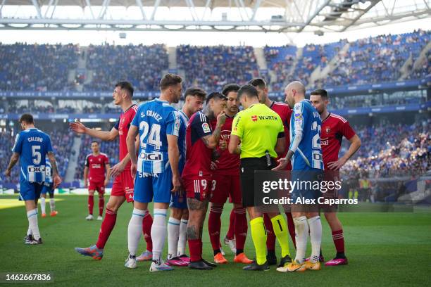 Ezequiel Avila and team mates of CA Osasuna interact with Match Referee Jesus Gil Manzano during the LaLiga Santander match between RCD Espanyol and...