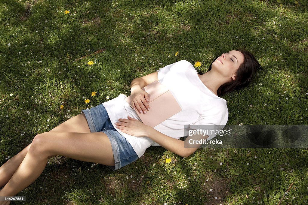 Young woman lying on meadow