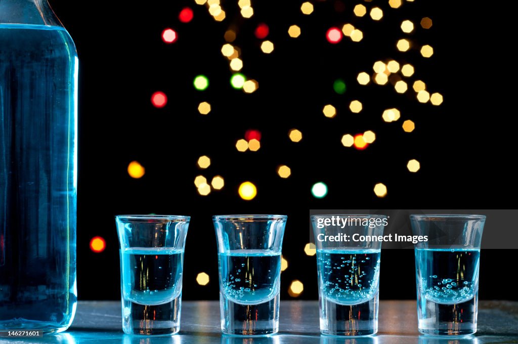 Bottle and shots of blue alcohol