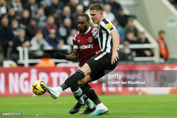Michail Antonio of West Ham United battles for possession with Sven Botman of Newcastle United during the Premier League match between Newcastle...