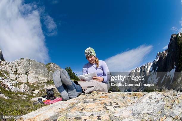 woman reading map at camp, picket pass, north cascades national park, washington state, usa - lost sock stock pictures, royalty-free photos & images