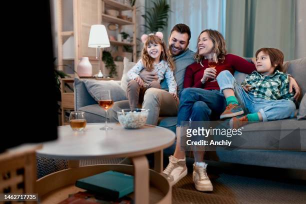feliz familia divirtiéndose - familia viendo la television fotografías e imágenes de stock