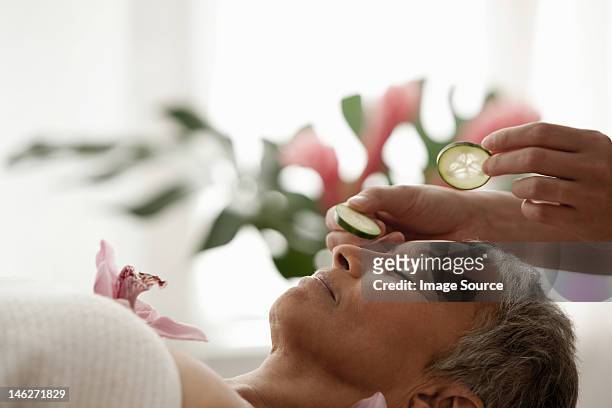 senior woman relaxing on massage table - indulgence stockfoto's en -beelden