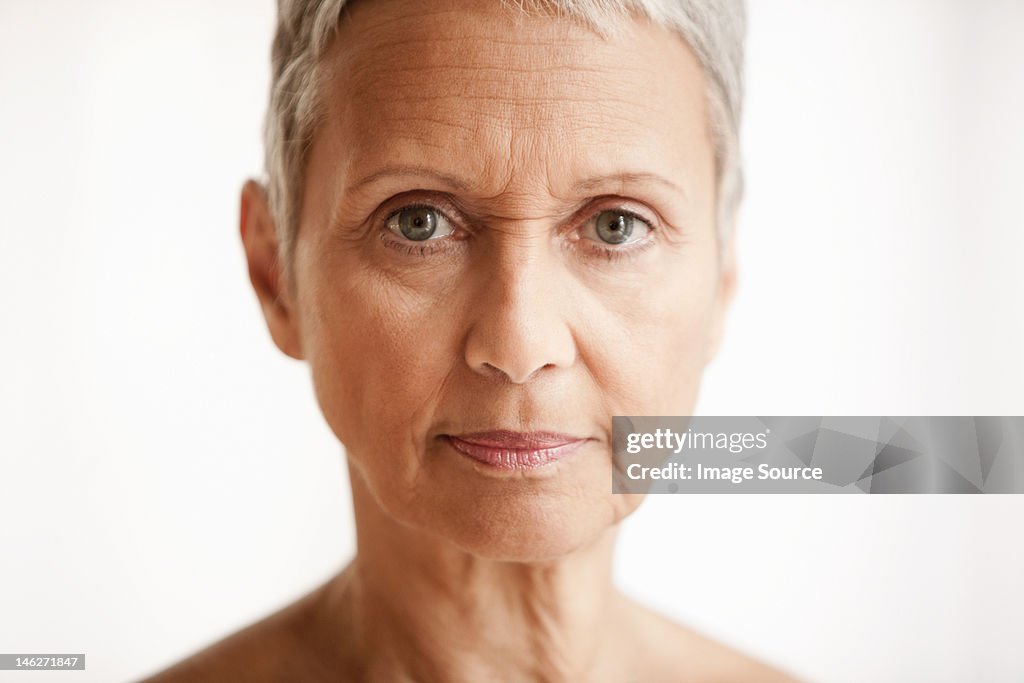 Senior woman against white background, portrait