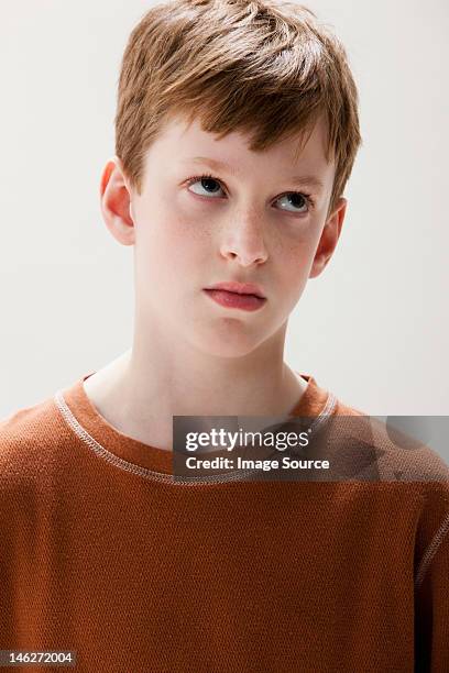 boy in brown sweater rolling eyes, studio shot - ぎょろ目 ストックフォトと画像