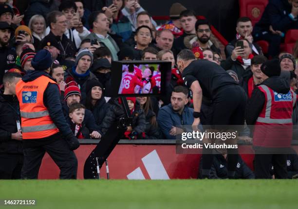 Referee Andre Marriner checks the pitchside VAR screen before showing a red card to Casemiro of Manchester United during the Premier League match...