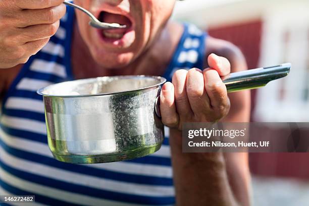 close up of man eating from saucepan - holding saucepan stock pictures, royalty-free photos & images