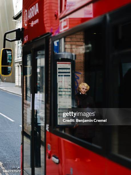 Woman is reflected in the window of a red bus on February 3, 2023 in London, England. Today, the Bank of England upped its base interest rate from...