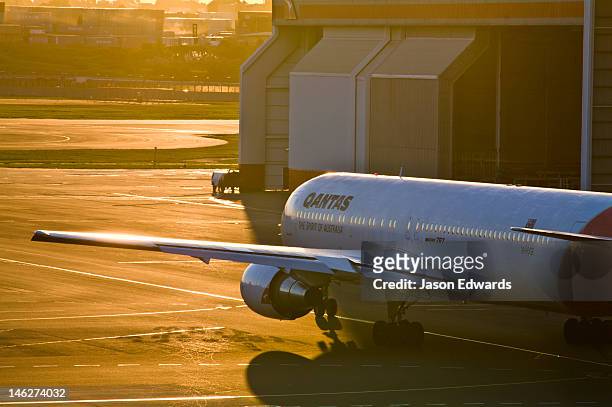 a jet airliner taxis from an airport hanger to the runway to take-off. - kingsford smith airport stock pictures, royalty-free photos & images