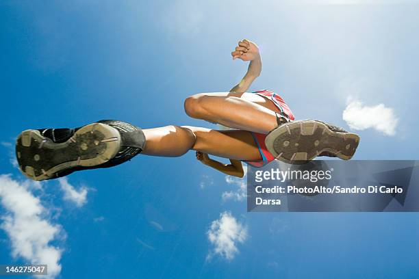 female athlete jumping in air, directly below - running shoes sky stock pictures, royalty-free photos & images