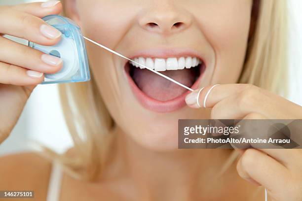 woman using dental floss, cropped - zahnseide stock-fotos und bilder