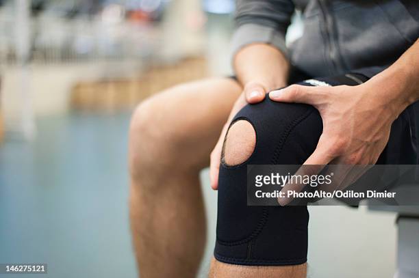 man wearing knee brace, cropped - orthopädie stock-fotos und bilder