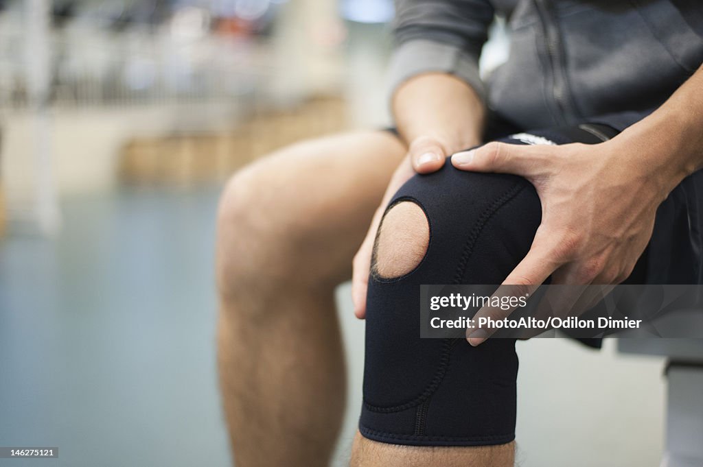 Man wearing knee brace, cropped