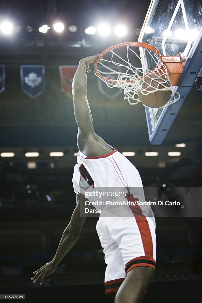 Basketball player slam dunking basketball