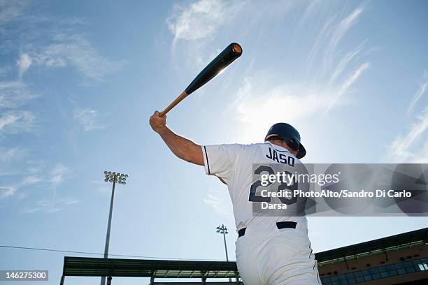 baseball player swinging bat, rear view - honkbaltenue stockfoto's en -beelden