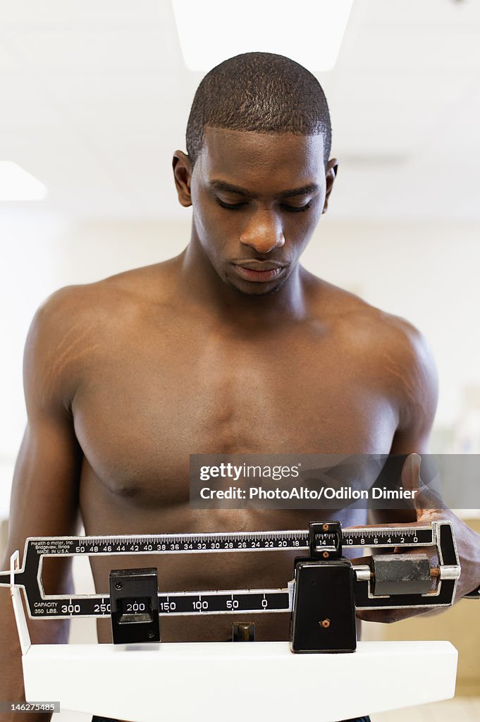 Young man standing on weight scale