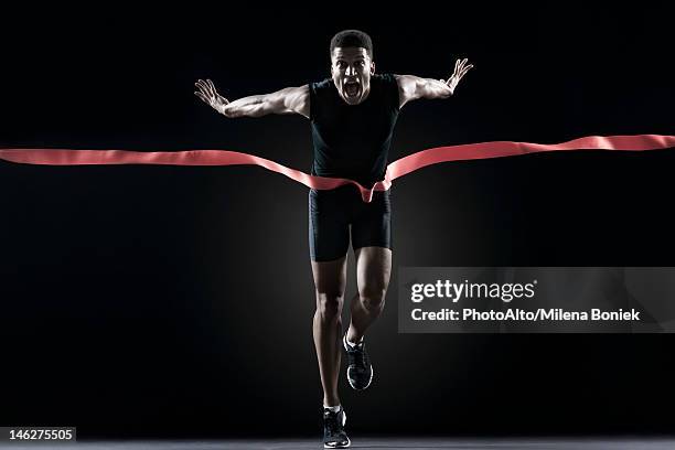 runner crossing finishing line - finish line ribbon stock pictures, royalty-free photos & images