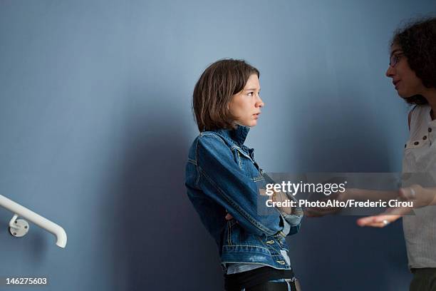 young woman apologizing to upset friend - apologize stockfoto's en -beelden