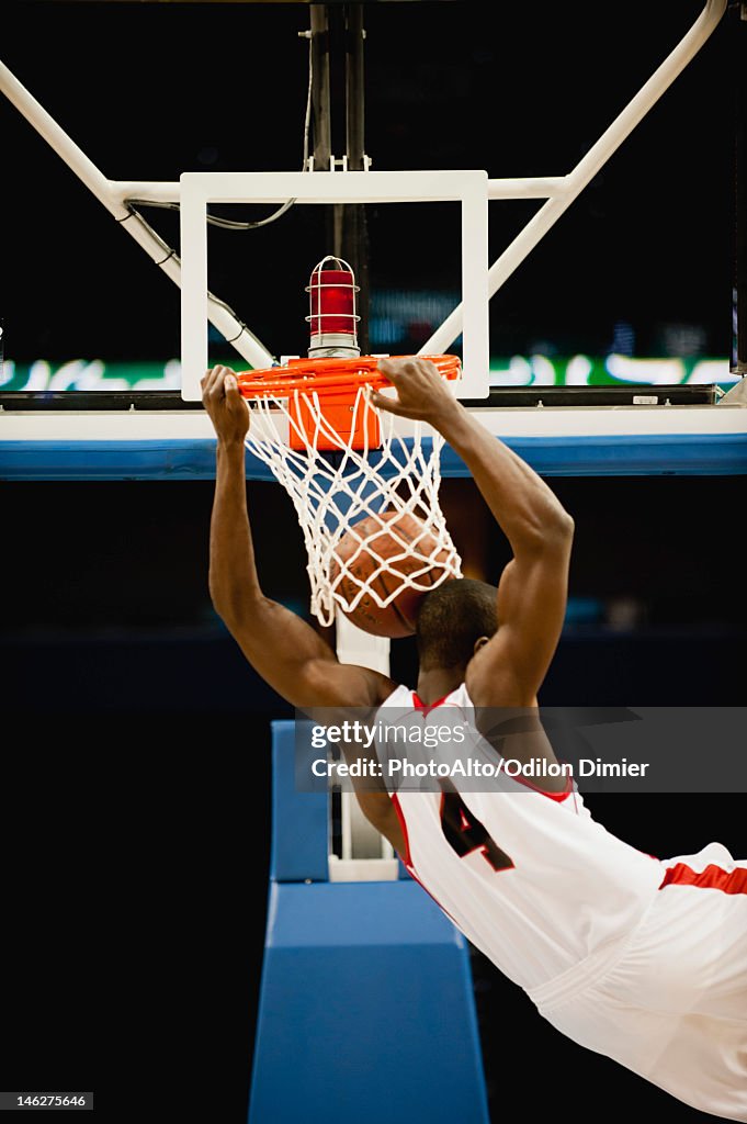 Basketball slam dunking, rear view