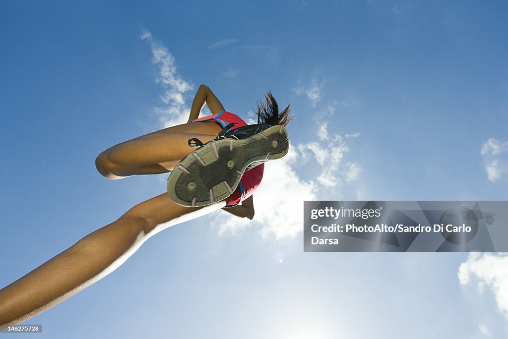 Female athlete jumping in air, directly below