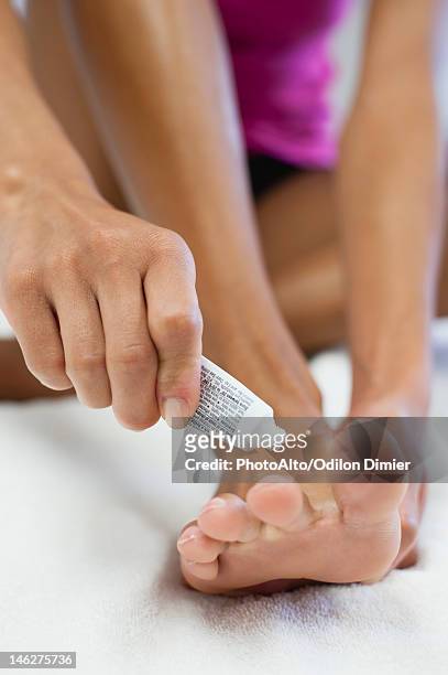woman applying ointment to foot, cropped - athlete's foot stock pictures, royalty-free photos & images