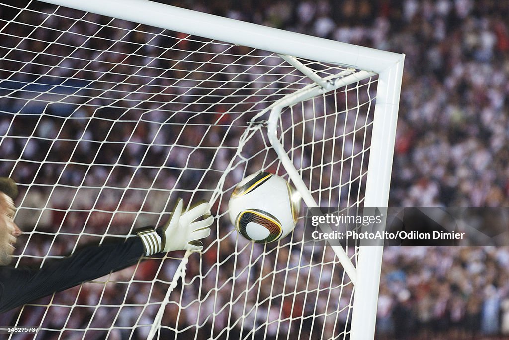 Soccer goalkeeper diving to block ball