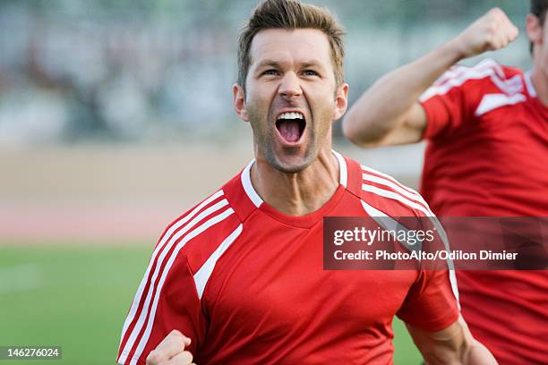 soccer player cheering - fußballtrikot stock-fotos und bilder