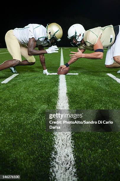 opposing football players crouched at line of scrimmage - football line of scrimmage stock pictures, royalty-free photos & images